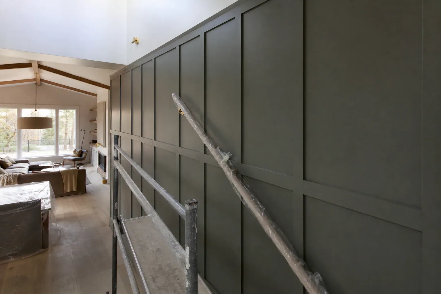 Custom cabinets in Boise Id — a stairwell wall being finished with the handrail wrapped in protective film